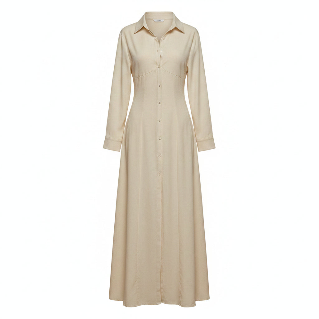 Woman wearing a long beige dress with a high slit in a room with white walls and a window.