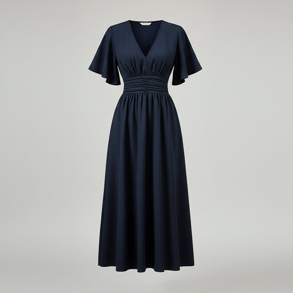Woman wearing a navy blue dress with a cactus plant in the background