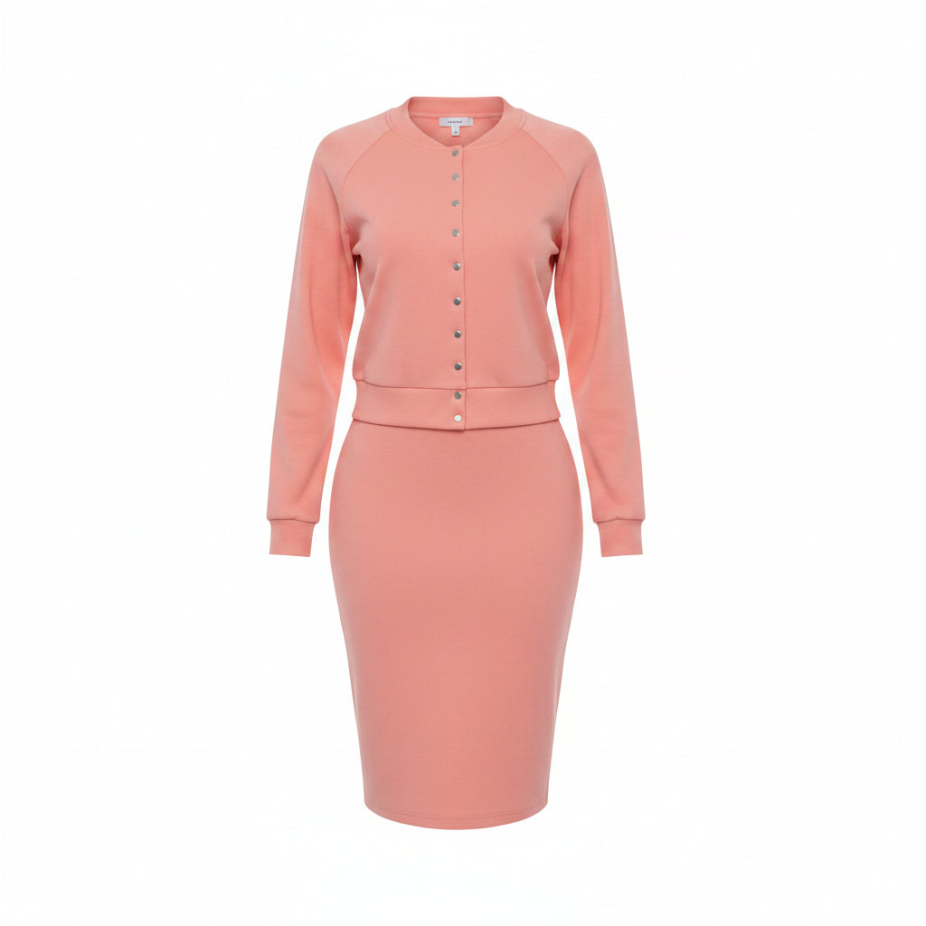 Woman wearing a pink outfit with a matching jacket and skirt in an outdoor setting.