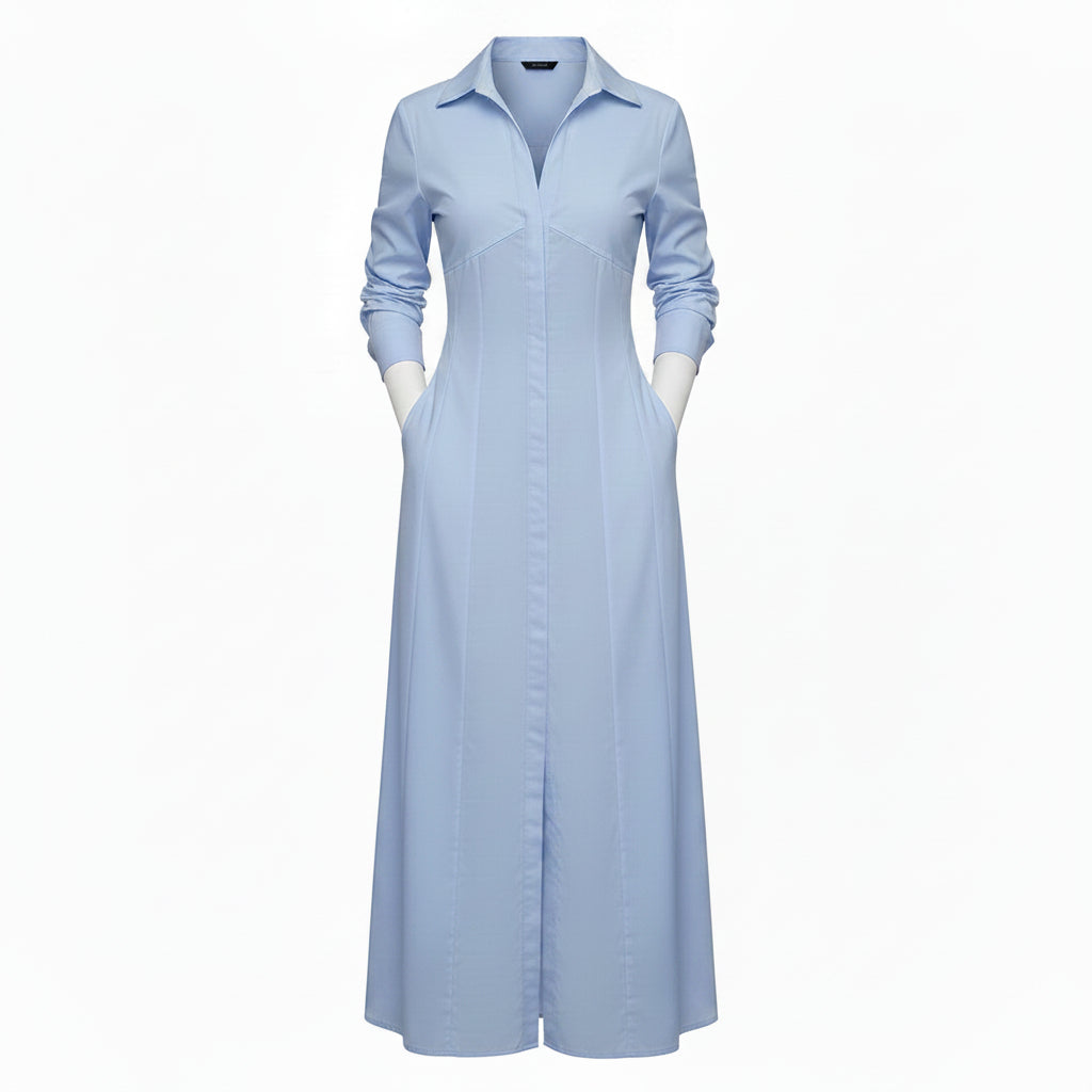 Woman wearing a long light blue dress with a high slit, standing against a neutral background.